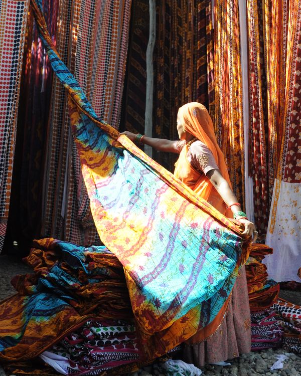 A woman hanging freshly dyed cloth in rural Rajasthan.
